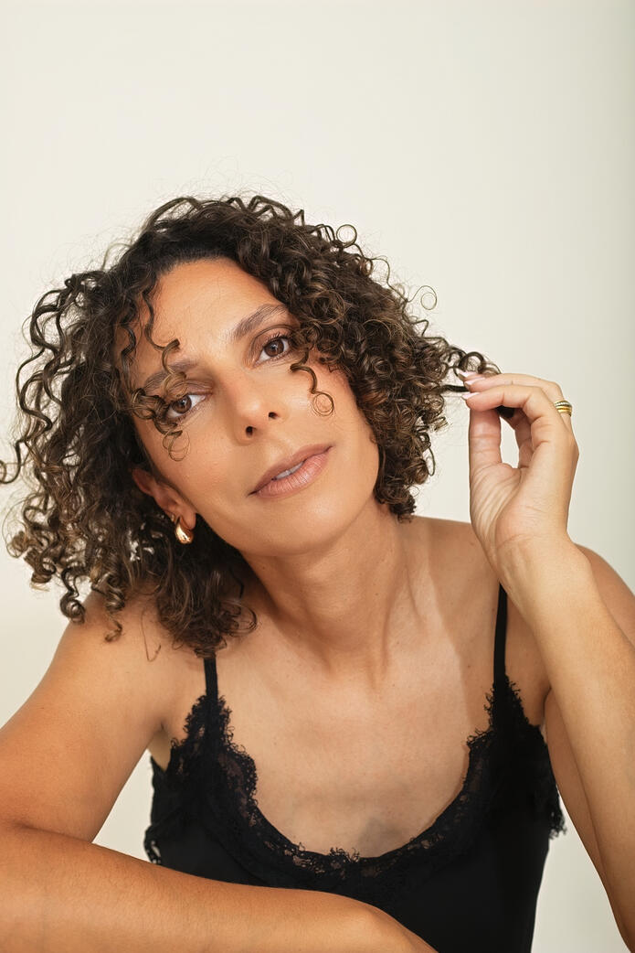 Photo of curly woman in black top, Berlin studio photoshoot